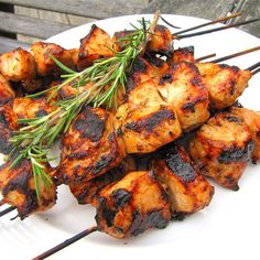 chicken skewers with herbs on a white plate