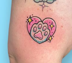 a heart shaped tattoo with a dog's paw and stars on the side of it