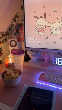 a laptop computer sitting on top of a desk next to a bowl of food and a cup