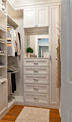 an organized closet with white drawers and shelves