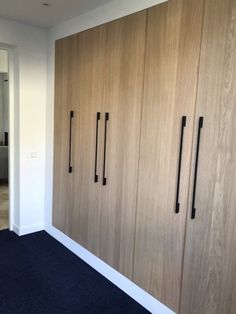 an empty room with wooden cabinets and carpeted flooring in front of the wall