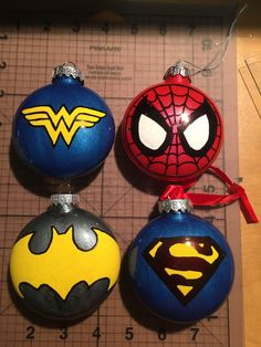 three ornaments with different designs on them sitting on a piece of paper next to a ruler