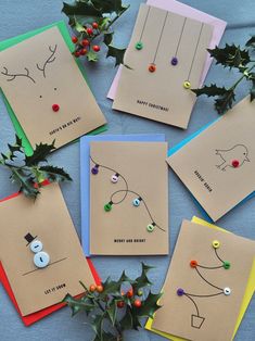 six christmas cards with buttons and holly on them, all lined up in a circle