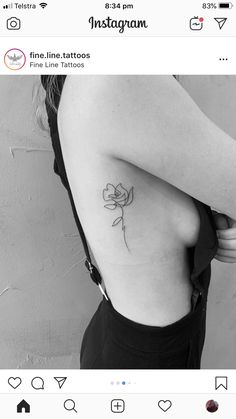 a black and white photo of a woman's back with a rose tattoo on it