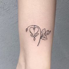 a small tattoo on the ankle of a woman's leg with leaves and flowers