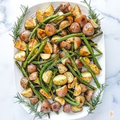 roasted potatoes and green beans on a white platter