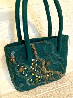 Bag felt made of 100%  wool , hand made . There lining with a zipper pocket .  Size ( 28 * 25 cm)   11*10 inch handle length 40-50 cm 100 % Wool , silk fiber , nettle , flax .  Handbag is combined with any fall or winter clothing. The bag is very easy. You can pin the flower and it will be a summer version of a handbag. This fashionable and stylish bag gives you individuality and  uniqueness Gift idea for her You can view other items in my store https://www.etsy.com/shop/makoshawool I ship your order within 1-3 business days after payment is confirmed. I use Etsy address, please make sure that it is correct. I will tell you the track number for tracking parcel. Standard international shipping takes up to 20 business days and accept through Ukrposhta.  In connection with the epidemic in the Handmade Green Bag For Gift, Handmade Green Shoulder Bag For Shopping, Green Tote Shoulder Bag As Gift, Green Handmade Tote Shoulder Bag, Handmade Green Tote Shoulder Bag, Handmade Felt Bag For Daily Use, Rectangular Felt Bags For Gifts, Rectangular Felt Bags As Gifts, Silk Fiber