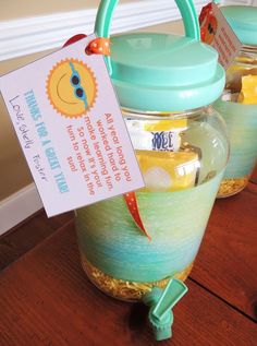 three jars filled with jelly sitting on top of a wooden table next to a sign