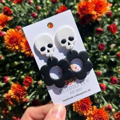 the skull earrings are black and white with skulls on them, as well as flowers