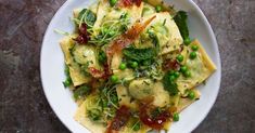 a white plate topped with ravioli and peas