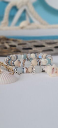 TitiTataStore.etsy.com Always FREE SHIPPING and a FREE GIFT! I Will Ship Within 24 Hours! Description: A Beautiful Set of 2 Coastal Style Beachy Bracelets.  Materials: 8mm Rondelle Blue Quartz Beads, 8mm Frosted White Sea Glass Beads, 8mm Matte Ivory Fossil Jasper Beads, 8mm Mystic Aura Quartz Beads, 8mm Natural Wood Beads, 8mm Natural White Matte Magnesite Beads, Seashells Heishi Beads, 8mm Matte Fossil Coral Riverstone, and 8mm Brushed Silver flat disc beads spacers. A Whale Tail charm adorned Bohemian Stackable Wrap Bracelet For Beach, Hand Wrapped Wrap Bracelet For Beach, Turquoise Wrap Bracelet For Beach, Blue Wrap Bracelet For Beach, Bracelets Seashell, Bracelets Beachy, Coastal Bracelet, Beachy Bracelets, Lover Birthday