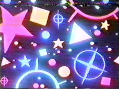 an image of colorful shapes and stars on a black background with white dots in the middle