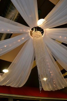 the ceiling is decorated with white drapes and lights