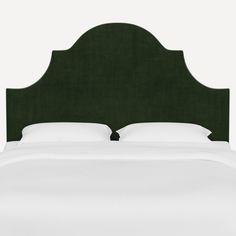 a green headboard with white sheets and pillows