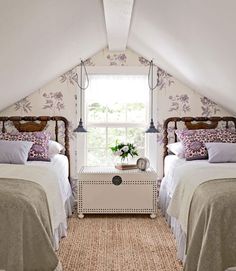 two beds in a room with white walls and carpeted flooring next to each other