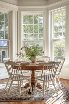 a dining room table with four chairs and a potted plant in the center on top