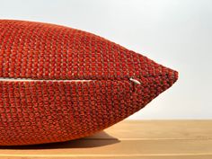 an orange pillow sitting on top of a wooden table