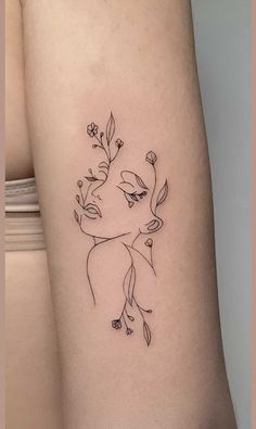 a woman's arm with flowers and leaves on the left side of her body