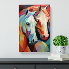 two horses standing next to each other in front of a white wall with a potted plant