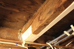 electrical wires are connected to the ceiling in an old house with wood beams and exposed pipes