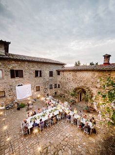 an outdoor dining area with tables and chairs set up for a formal dinner in the evening