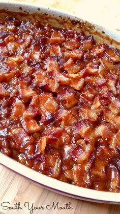 a casserole dish filled with bacon on top of a wooden table