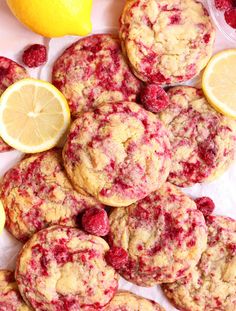 raspberry lemon muffins are piled on top of each other next to sliced lemons