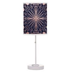 a table lamp with a blue and pink flower design on the shade, it is lit up