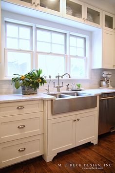 a clean kitchen with white cabinets and stainless steel sink, dishwasher and window