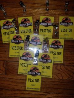 a bunch of yellow visitor tags on a wooden floor with clippings attached to them