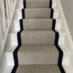 the carpeted stairs are lined with black and white chevron rugs on them