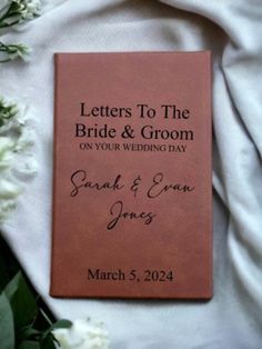 a wedding book laying on top of white flowers