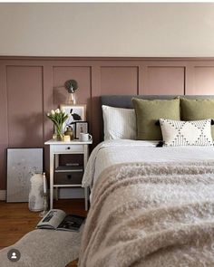 a bedroom with pink walls and white bedding