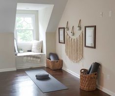 a yoga mat is on the floor in front of a window and some pictures are hanging on the wall