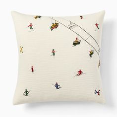 a white pillow with skiers skiing down the hill on skis and snowboards