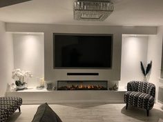 a large flat screen tv mounted to the wall above a fireplace in a living room