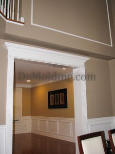 an open door leading into a living room with hard wood flooring and white trim