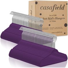 three purple combs sitting next to each other in front of a cardboard box on a white surface