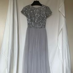 a dress hanging on a hanger in front of a white wall