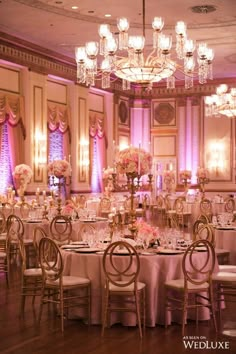 an elegant ballroom with chandeliers, tables and chairs