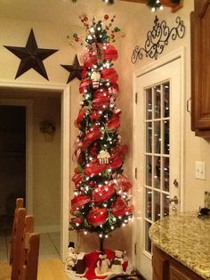 a decorated christmas tree in the corner of a kitchen