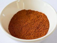 a white bowl filled with spices on top of a table