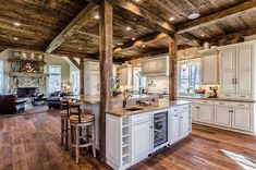 a large kitchen with an island in the middle and lots of wood on the ceiling