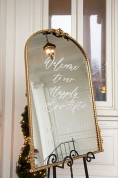 a mirror with a welcome sign on it in front of a door and christmas tree