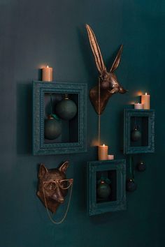 the wall is decorated with candles, ornaments and an animal's head on it