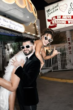 a man in a tuxedo carrying a woman on his back