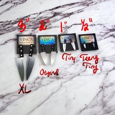 three knives are sitting next to each other on a marble surface with the words king and queen in red