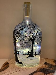 a glass bottle with a tree painted on it