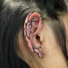 a woman with black and white tattoos on her ear