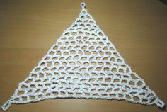 a crocheted triangle sitting on top of a wooden table